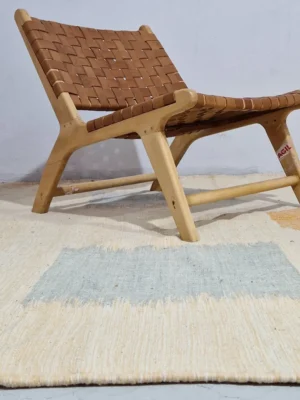 Neutral Handmade Moroccan Kilim rug with a minimalist orange diamond pattern in wall decorated room