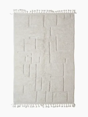 Moroccan hand-knotted ivory wool rug with raised geometric pattern and tassels