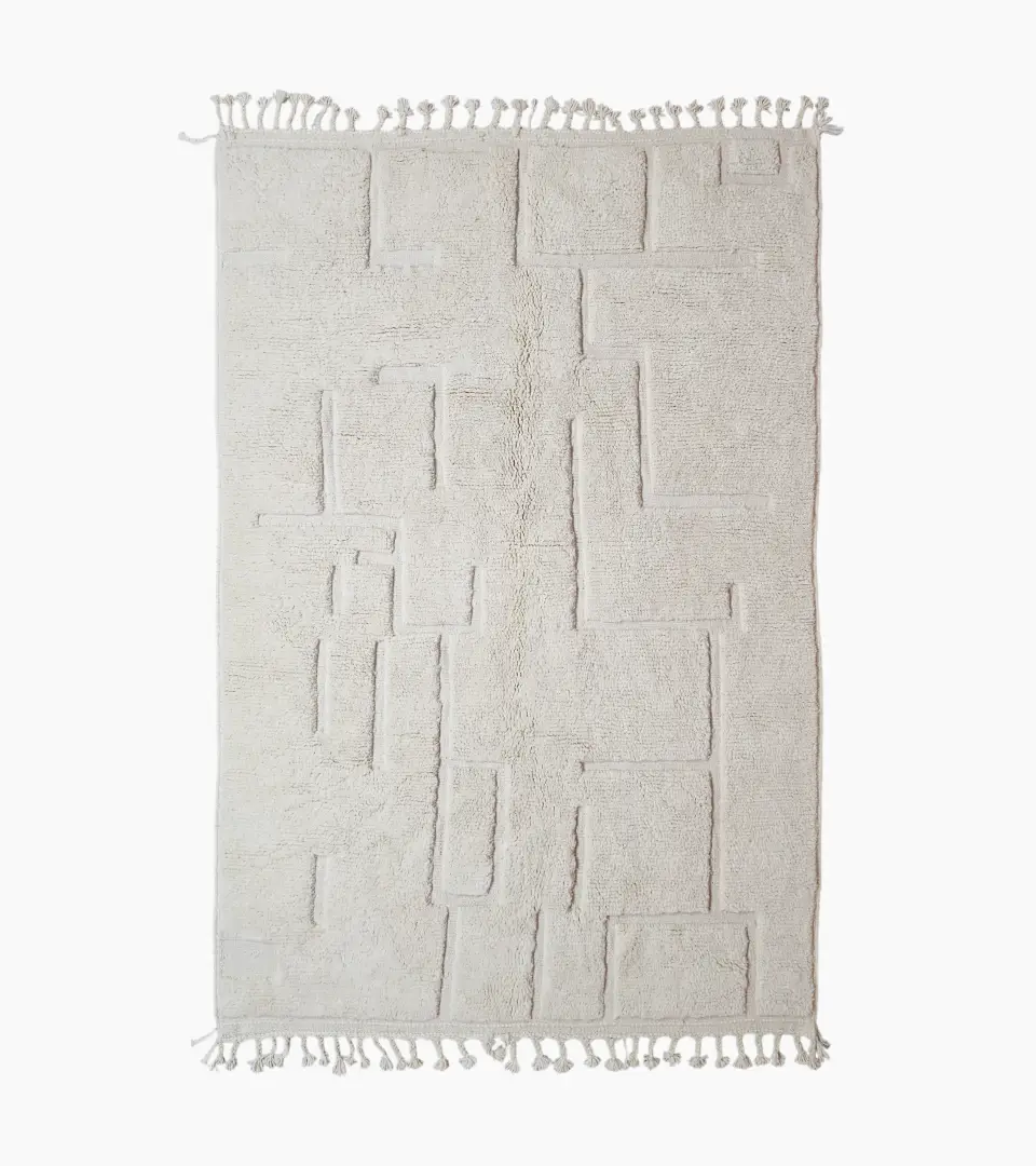 Moroccan hand-knotted ivory wool rug with raised geometric pattern and tassels