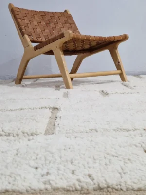 Neutral Handmade Moroccan high-low wool rug with a geometric pattern in well decorated room