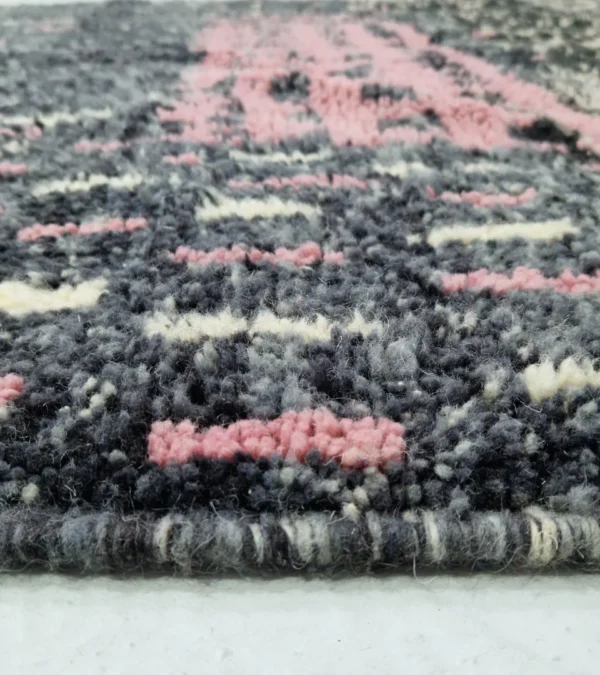 Zoomed In View of Handmade Moroccan wool rug with an abstract striped design in rose pink and charcoal