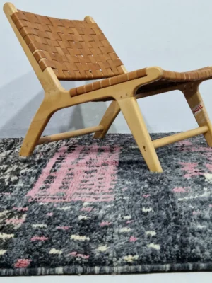 Handmade Moroccan wool rug with an abstract striped design in rose pink and charcoal in room