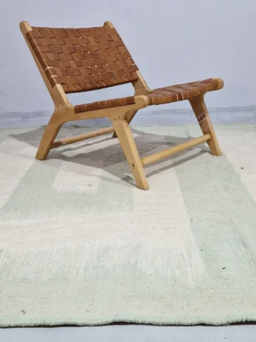 Adel handmade Kilim flatweave wool rug with a pale green background and a white geometric pattern in room