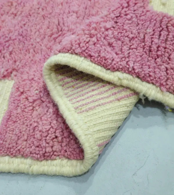 Detailed View of Aivra handmade Beni Ourain wool rug with a minimalist pink and ivory labyrinth design