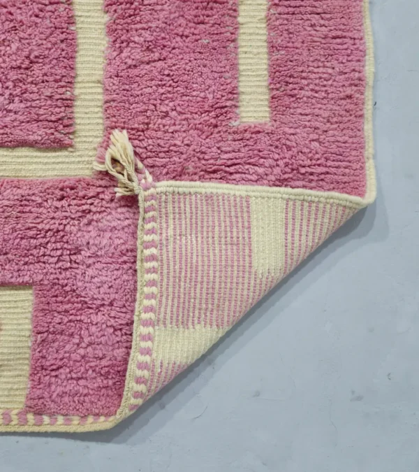 Detailed View of Aivra handmade Beni Ourain wool rug with a minimalist pink and ivory labyrinth design