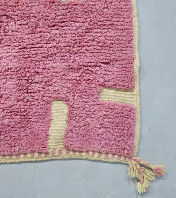 Detailed View of Aivra handmade Beni Ourain wool rug with a minimalist pink and ivory labyrinth design