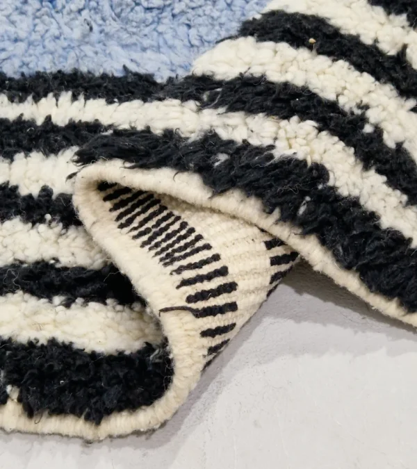 Detailed View of Handmade Moroccan wool rug with a minimalist block and stripe design in blue, black, and white
