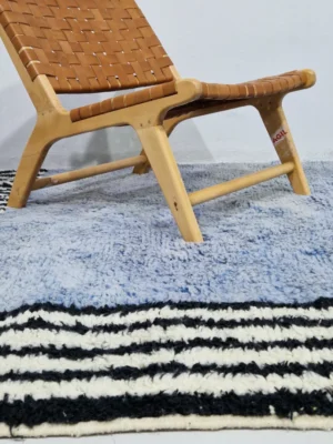 Handmade Moroccan wool rug with a minimalist block and stripe design in blue, black, and white in room