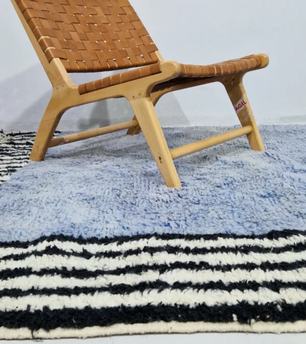 Handmade Moroccan wool rug with a minimalist block and stripe design in blue, black, and white in room