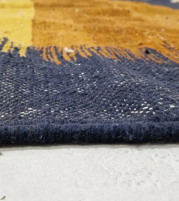 Zoomed In View of Alice handmade Kilim flatweave rug with a boho geometric design in navy, yellow, brown, and white