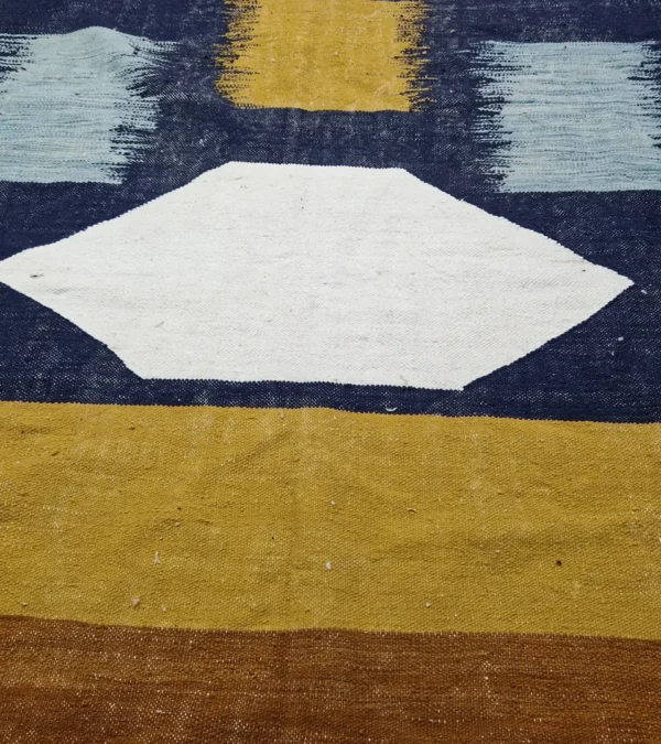 Detailed View of Alice handmade Kilim flatweave rug with a boho geometric design in navy, yellow, brown, and white