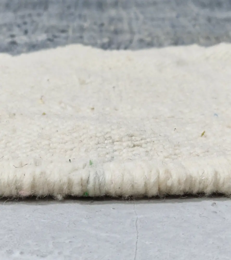 Zoomed In View of Aline handmade Beni Ourain flatweave rug with a modern jagged pattern in blue, brown, and ivory