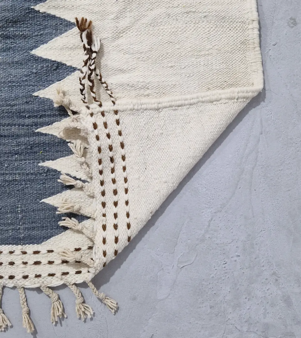 Detailed View of Aline handmade Beni Ourain flatweave rug with a modern jagged pattern in blue, brown, and ivory