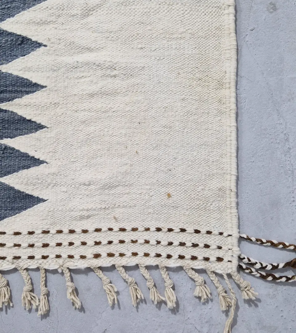 Detailed View of Aline handmade Beni Ourain flatweave rug with a modern jagged pattern in blue, brown, and ivory