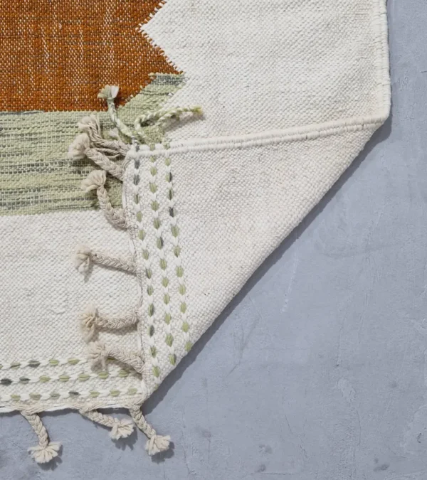 Detailed View of Aline handmade Kilim flatweave rug with a sawtooth pattern in brown, light green, and ivory
