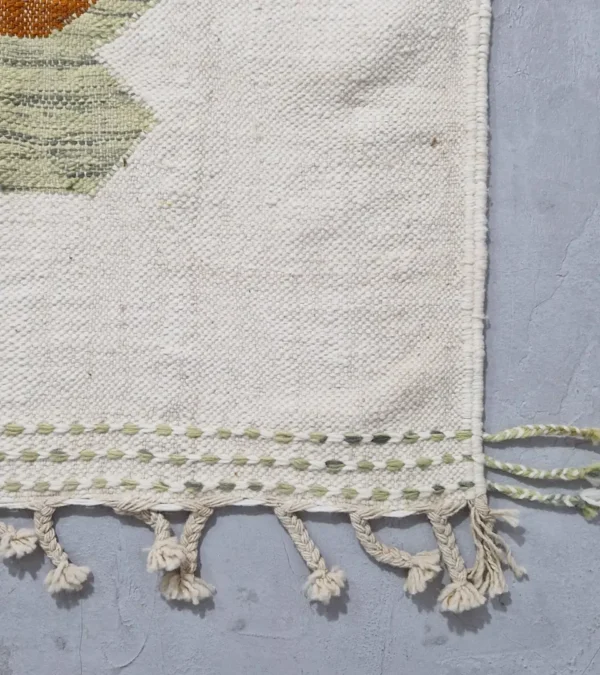 Detailed View of Aline handmade Kilim flatweave rug with a sawtooth pattern in brown, light green, and ivory