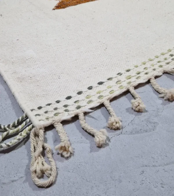 Detailed View of Aline handmade Kilim flatweave rug with a sawtooth pattern in brown, light green, and ivory