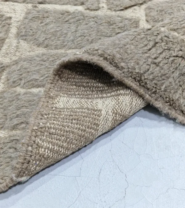 Detailed View of Anis handmade Beni Ourain wool rug with a subtle abstract geometric design in textured taupe and ivory