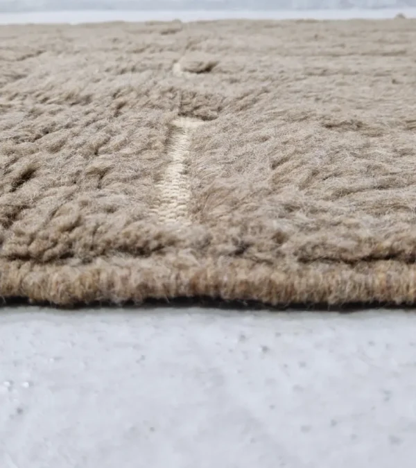 Zoomed In View of Anis handmade Beni Ourain wool rug with a subtle abstract geometric design in textured taupe and ivory