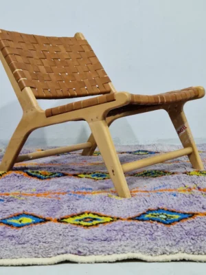 Handmade Moroccan wool rug with a diamond trellis pattern in yellow, blue, and orange on lavender in room