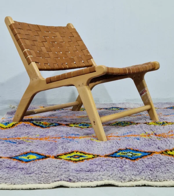 Handmade Moroccan wool rug with a diamond trellis pattern in yellow, blue, and orange on lavender in room