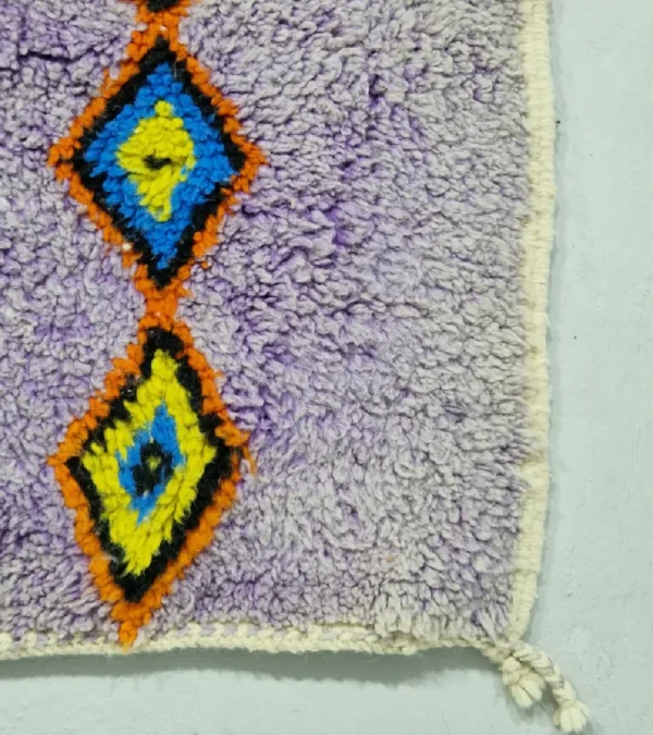 Handmade Moroccan wool rug with a diamond trellis pattern in yellow, blue, and orange on lavender