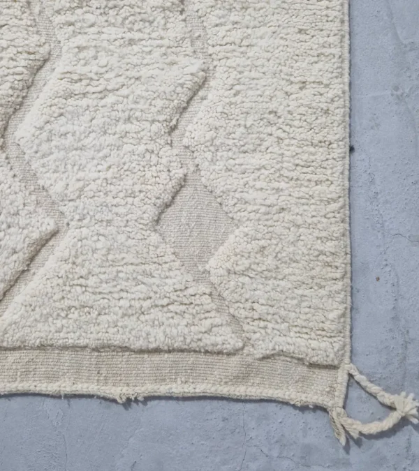 Detailed View of Berry handmade Beni Mrirt wool rug with a subtle raised geometric pattern on an ivory background