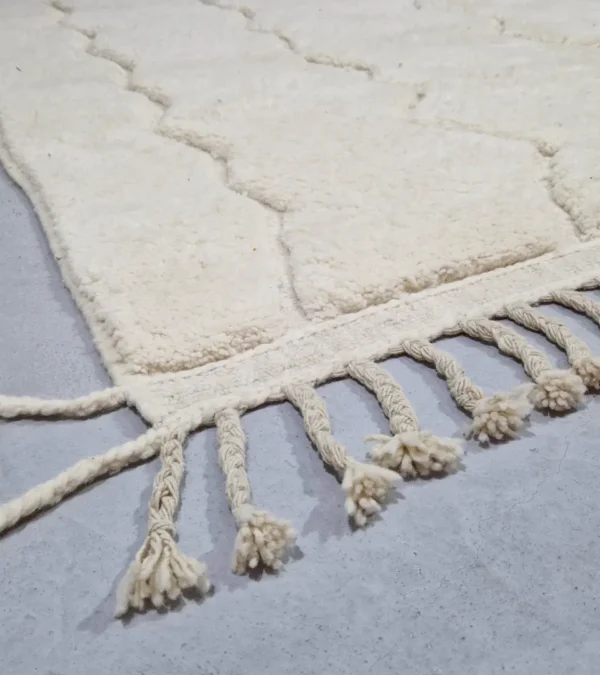 Detailed View of Berry handmade Beni Mrirt wool rug with a subtle raised geometric pattern on an ivory background