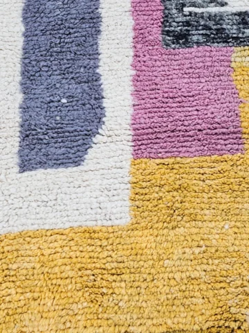 Detailed View of Handmade Azilal wool runner with a boho abstract colorblocked design in yellow, pink, lavender, gray, and ivory