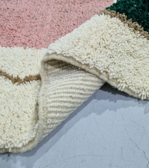 Detailed View of Handmade Moroccan wool rug with a Mid-Century abstract design in teal, brown, pink, and black