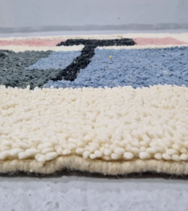 Zoomed In View of Handmade Moroccan wool rug with a Mid-Century abstract design in teal, brown, pink, and black