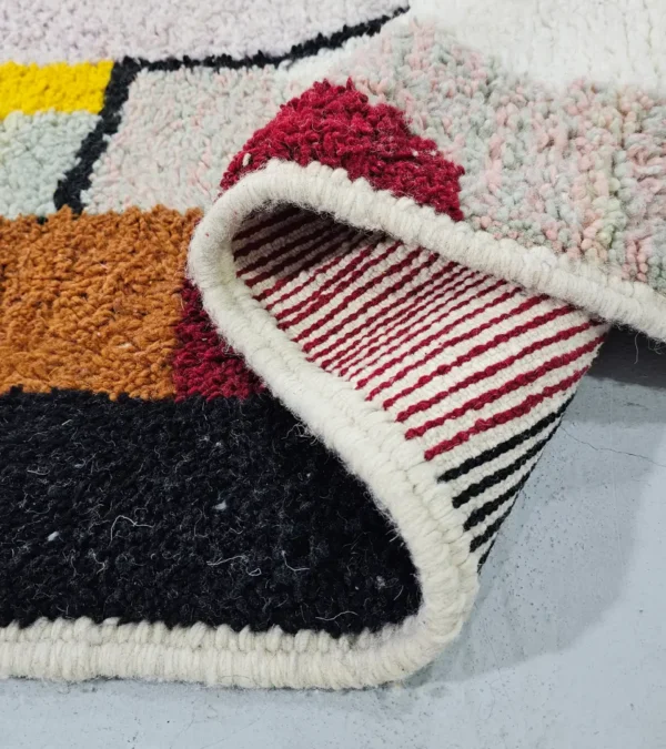 Detailed View of Handmade Azilal wool rug with a vibrant and complex abstract geometric design in multiple colors