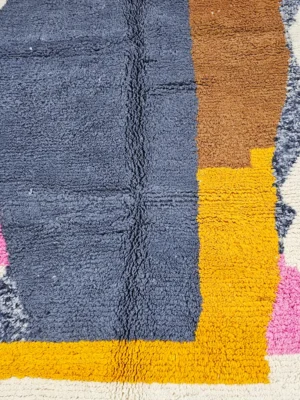 Detailed View of Handmade Beni Ourain wool rug with a contemporary abstract design in blue, brown, pink, and yellow