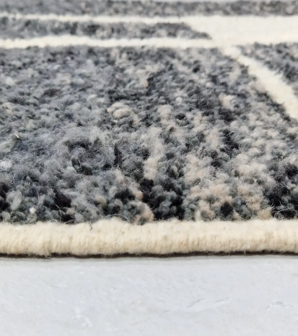 Zoomed In View of Cora handmade Beni Mrirt wool rug with a modern textured pattern in charcoal gray and ivory