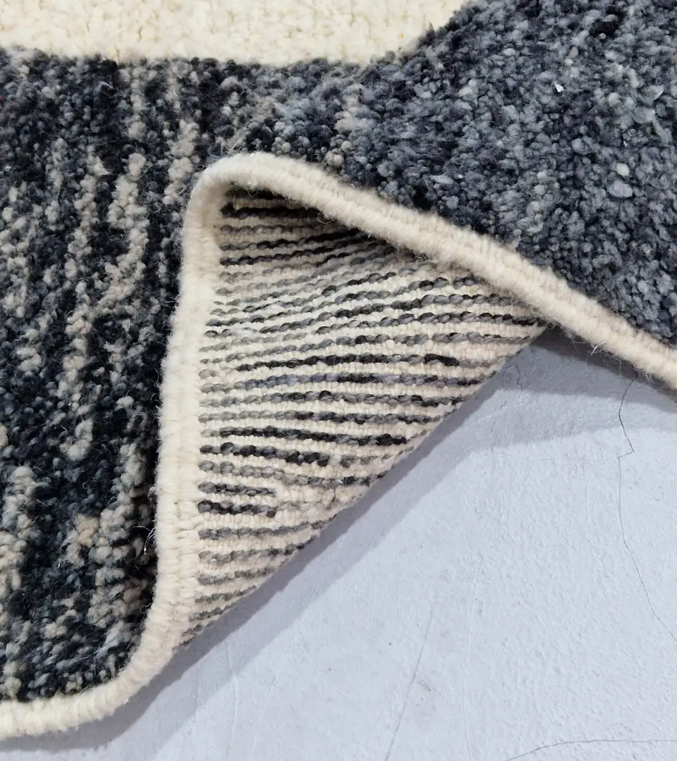Detailed View of Cora handmade Beni Mrirt wool rug with a modern textured pattern in charcoal gray and ivory