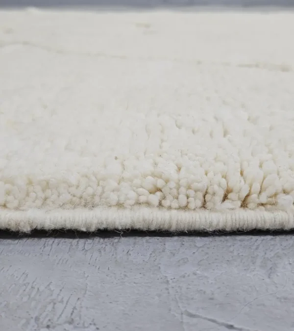 Zoomed In View of Dora handmade Beni Mrirt wool rug with a subtle geometric design in ivory created by a textured high/low pile