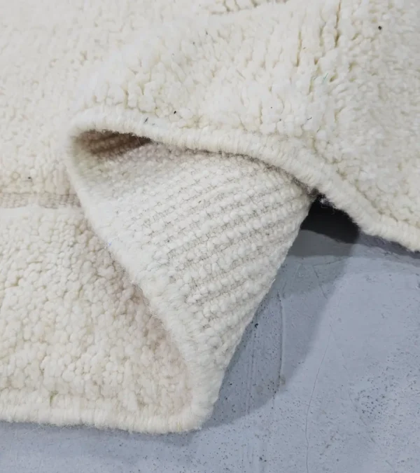 Detailed View of Dora handmade Beni Mrirt wool rug with a subtle geometric design in ivory created by a textured high/low pile