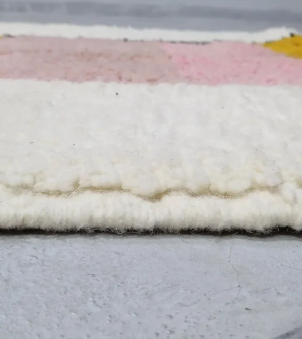 Zoomed In View of Elara handmade Beni Ourain wool rug with a colorful block design in vibrant pink, mustard yellow, and charcoal gray
