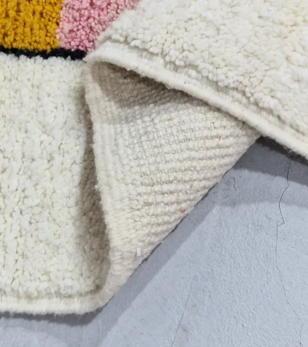 Detailed View of Elara handmade Beni Ourain wool rug with a colorful block design in vibrant pink, mustard yellow, and charcoal gray