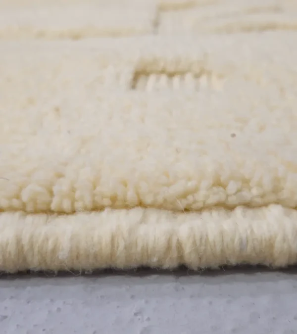 Zoomed In View of Eleni handmade Beni Mrirt wool rug with a minimalist ivory geometric design