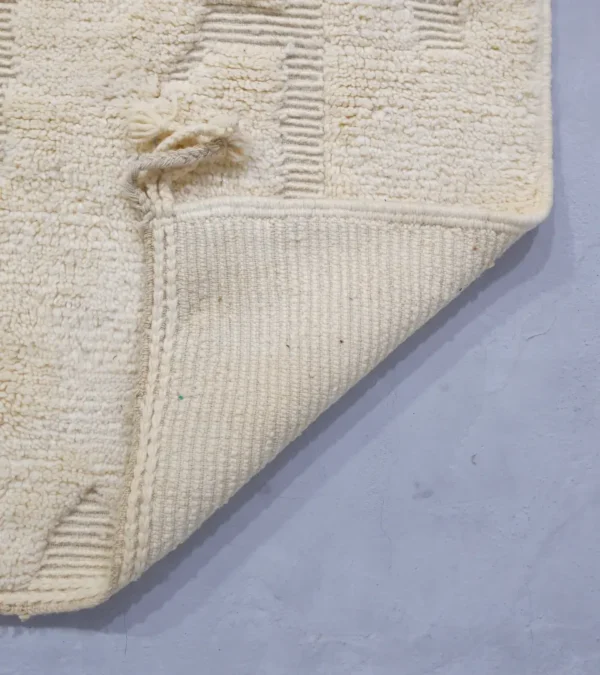 Detailed View of Eleni handmade Beni Mrirt wool rug with a minimalist ivory geometric design