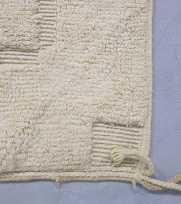 Detailed View of Eleni handmade Beni Mrirt wool rug with a minimalist ivory geometric design