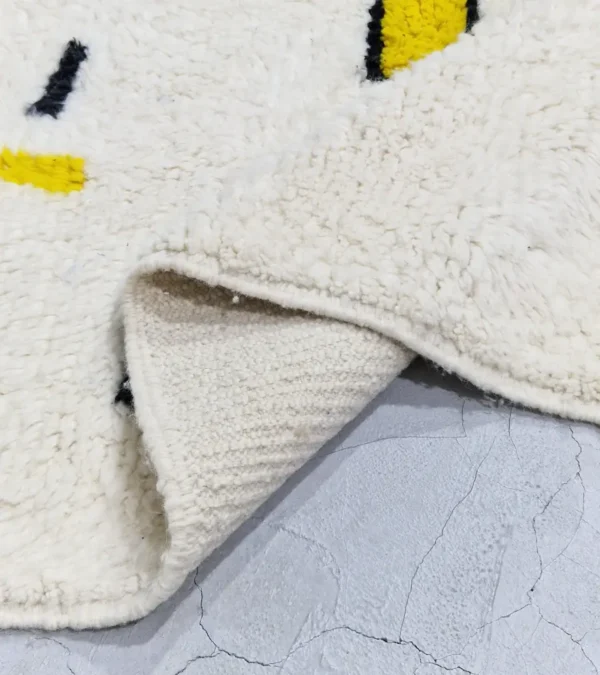 Detailed View of Elly handmade Azilal wool rug with a whimsical abstract design of lines and shapes in black and yellow