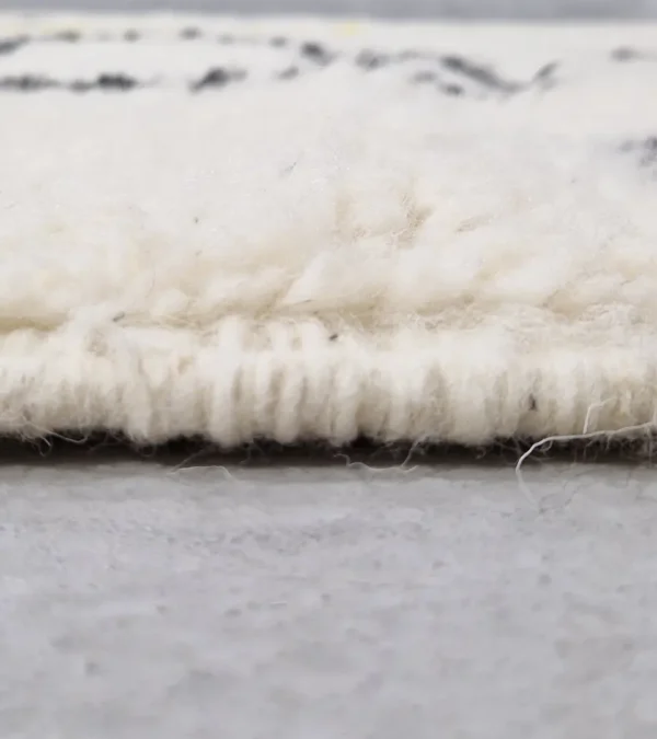 Zoomed In View of Elly handmade Azilal wool rug with a whimsical abstract design of lines and shapes in black and yellow