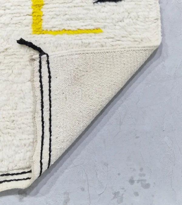 Detailed View of Elly handmade Azilal wool rug with a whimsical abstract design of lines and shapes in black and yellow