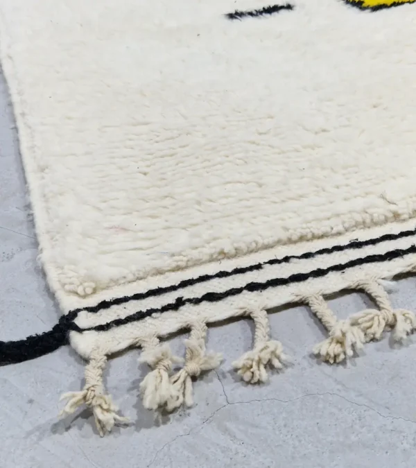 Detailed View of Elly handmade Azilal wool rug with a whimsical abstract design of lines and shapes in black and yellow