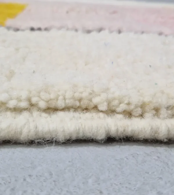 Zoomed View of Elly handmade wool rug with a minimalist pastel colorblocked design in pink, yellow, and gray