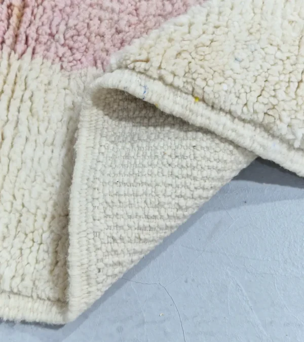 Detailed View of Elly handmade wool rug with a minimalist pastel colorblocked design in pink, yellow, and gray