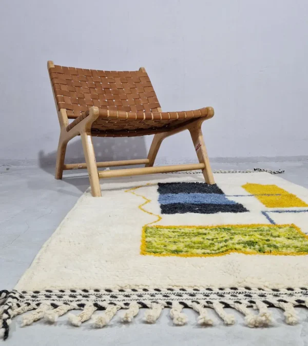 Emy handmade Beni Ourain wool rug with a modern abstract design featuring green, yellow, navy blue, light blue, and white color blocks outlined in yellow in room