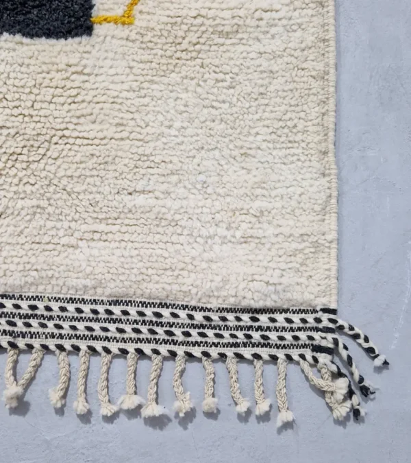 Detailed View of Emy handmade Beni Ourain wool rug with a modern abstract design featuring green, yellow, navy blue, light blue, and white color blocks outlined in yellow